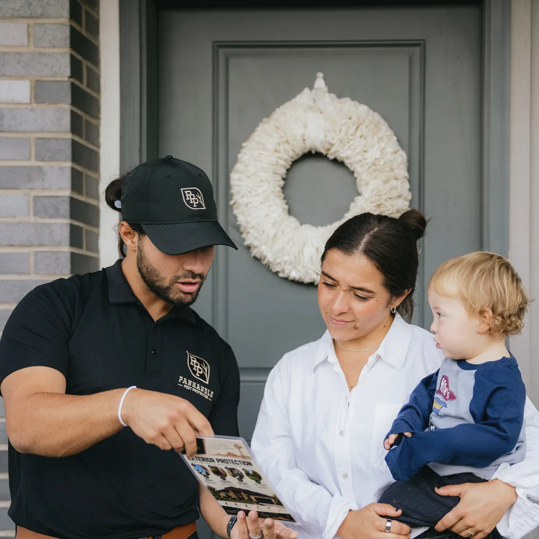 Pest control technician discussing service with a homeowner